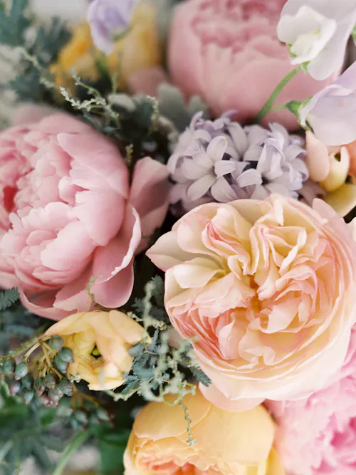 Close-up of blush garden roses, pink peonies, hyacinths, and soft spring flowers in a pastel bouquet