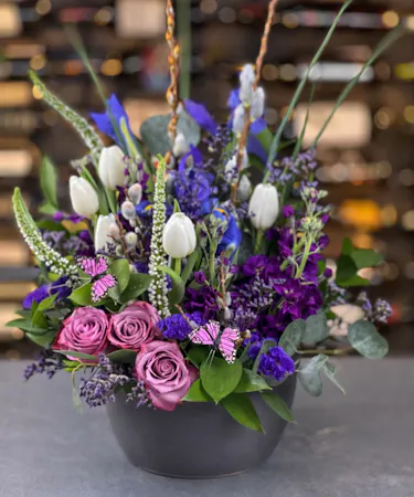 Lavender roses, blue iris, and white tulips in spring bowl delivered in Columbus, Ohio.