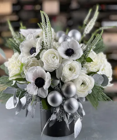 White anemone and ranunculus winter flower arrangement with silver accents in black vase – Griffin’s Floral Design