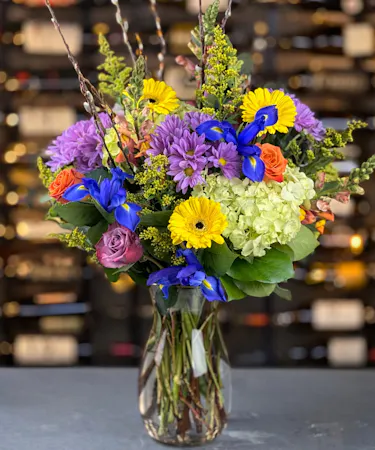 Colorful spring bouquet with iris, gerbera daisies, and hydrangea in glass vase delivered in Columbus, Ohio.