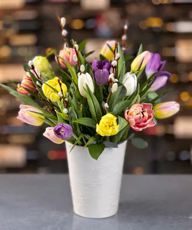 A vibrant bouquet of assorted  colorful tulips in a glass vase. Available for same-day delivery in Columbus, New Albany, and Newark, OH from Griffin’s Floral Design.