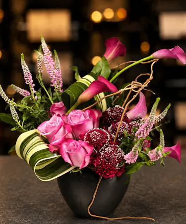 Modern Memphis botanical arrangement with pink roses, calla lilies, and artistic foliage in Columbus, Ohio.